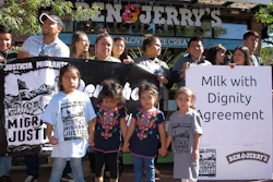 Children stand in front of a banner commemorating an agreement signed by ice cream maker Ben & Jerry's and immigrant farm workers, Tuesday, Oct. 3, 2017, in Burlington, Vt. The agreement promotes the rights of immigrant farm workers while paying more to the farmers who employ them. The company and the workers said it's the first agreement of its kind in the dairy industry.