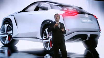 Nissan Motor Co. Executive Vice President Daniele Schillaci speaks with an image of Nissan IMX concept car during the media preview of the Tokyo Motor Show in Tokyo Wednesday, Oct. 25, 2017.