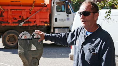 In this Wednesday, Oct. 11, 2017 photo, Wade Beal, parking meter technician, answers a question during an interview in Oklahoma City. The city where parking meters were born says it’s doing away with the last of its ancient, coin-operated models by the end of the year to make way for newer ones. Technology inside Oklahoma City’s old-school meters dated to the 1960s and 1970s, and many companies that once serviced them have long been out of business.