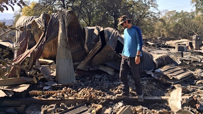 In this photo taken Oct. 15, 2017, Marcos Morales, co-founder of pot company Legion of Bloom, stands on the ruins of a state-of-the-art drying shed in Glen Ellen, Calif., where 1,600 pounds of ready-to-ship bud were destroyed in a fire.
