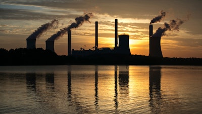 In this June 3, 2017, file photo, the coal-fired Plant Scherer, one of the nation's top carbon dioxide emitters, stands in the distance in Juliette, Ga. The Trump administration intends to roll back the centerpiece of former President Barack Obama’s efforts to slow global warming, seeking to ease restrictions on greenhouse gas emissions from coal-fired power plants.