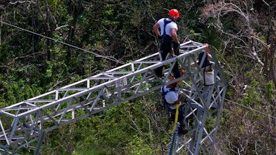 In this Oct. 15, 2017, file photo, Whitefish Energy Holdings workers restore power lines damaged by Hurricane Maria in Barceloneta, Puerto Rico. The Federal Emergency Management Agency said Oct. 27, it had no involvement in the decision to award a $300 million contract to help restore Puerto Rico's power grid to a tiny Montana company in Interior Secretary Ryan Zinke’s hometown. FEMA said in a statement that any language in the controversial contract saying the agency approved of the deal with Whitefish Energy Holdings is inaccurate.