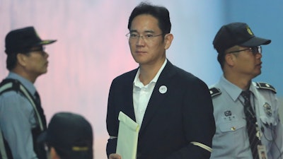 Lee Jae-yong, center, vice chairman of Samsung Electronics, arrives at the Seoul Central District Court for a hearing in Seoul, South Korea, Thursday, Oct. 12, 2017.