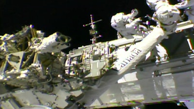 In this frame from NASA TV, Astronauts Mark Vande Hei, left, and Randy Bresnik work on the International Space Station on Thursday, Oct. 5, 2017. The astronauts went out on a spacewalk to give the International Space Station’s big robot arm a new hand.