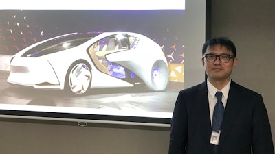 Toyota Motor Corp. manager Makoto Okabe stands in front of a image of the concept car 'TOYOTA Concept-i' series Monday Oct. 16, 2017 in Tokyo. The use of artificial intelligence means cars may get to know drivers as human beings by analyzing their facial expressions, driving habits and social media use.
