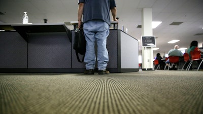 In this Friday, March 10, 2017, file photo, a lone job seeker checks in at the front desk of the Texas Workforce Solutions office in Dallas. On Thursday, Oct. 19, 2017, the Labor Department reports on the number of people who applied for unemployment benefits a week earlier.