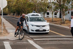 This Sunday, Oct. 29, 2017, photo provided by Waymo shows a Chrysler Pacifica minivan equipped with Waymo's self-driving car technology, being tested with the company's employees as a biker and a pedestrian at Waymo's facility in Atwater, Calif. Waymo, hatched from a Google project started eight years ago, showed off its progress Monday during a rare peek at a closely guarded testing facility located 120 miles southeast of San Francisco where its robots complete their equivalent to driver's education.