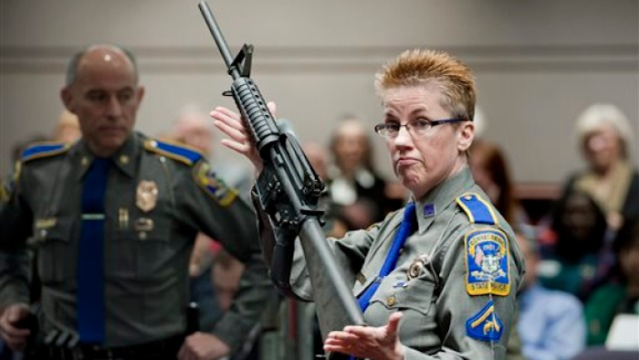 In this Jan. 28, 2013, file photo, firearms training unit Detective Barbara J. Mattson, of the Connecticut State Police, holds up a Bushmaster AR-15 rifle, the same make and model of gun used by Adam Lanza in the Sandy Hook School shooting, during a hearing of a legislative subcommittee, at the Legislative Office Building in Hartford, Conn.