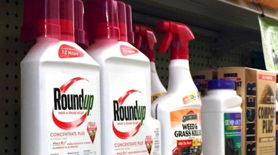 Containers of Roundup, left, a weed killer is seen on a shelf with other products for sale at a hardware store in Los Angeles.