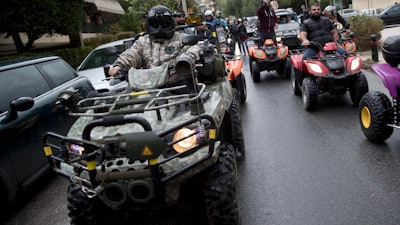 Protesters drive their all-terrain vehicles, ATV, during a rally outside Greek Transport Ministry in Athens, Monday, Nov. 13, 2017. Hundreds of four-wheel motorbike owners, most from Greek holiday resorts, have blocked traffic outside the country's Transport Ministry to protest a proposed vehicle ban.