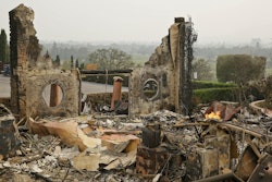 In this Oct. 10, 2017 file photo, the remains of the Signorello Estate winery continue to smolder in Napa, Calif. A month after deadly wildfires swept through California's famed wine country. Lost in the fire was the Napa winery’s signature stone hospitality building. A kitchen, corporate offices, a wine lab and the home of owner Ray Signorello Jr. also were destroyed.