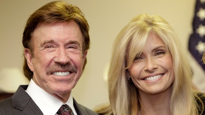 In this Dec. 2, 2010 file photo, actor Chuck Norris, left, and his wife Gena pose for a photo following a ceremony in Garland, Texas. Norris is taking on medical device manufacturers in a lawsuit alleging a chemical used in MRI imaging scans poisoned his wife. The lawsuit filed on Wednesday, Nov. 1, 2017, in San Francisco says gadolinium that doctors injected into Gena Norris to improve the clarity of her MRIs have left her weak and tired and with debilitating bouts of pain and a burning sensation.