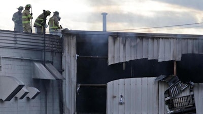 Firefighters work at the scene of a factory fire in New Windsor, N.Y., Monday, Nov. 20, 2017. Authorities say two explosions and a fire at the Verla International cosmetics factory in the Hudson Valley about an hour north of New York City have left multiple people injured, including firefighters caught in the second blast.
