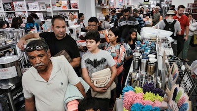 Thanksgiving holiday shoppers wait in a check out line at the JCPenny store in Glendale, Calif., Thursday, Nov. 23, 2017. Shoppers are hitting the stores on Thanksgiving as retailers under pressure look for ways to poach shoppers from their rivals. As the holiday shopping season officially kicked off, retailers are counting on a lift from a better economy.