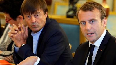 In this Sept.5 2017 file photo, French President Emmanuel Macron, right, and Environment Minister Nicolas Hulot meet with NGOs to discuss climate and environment at the Elysee Palace in Paris. Macron is planning a climate summit next month to push his 'Make our Planet Great Again' agenda, and to unveil the winners of his fellowship competition for U.S. climate scientists frustrated by the Trump administration's attitude toward global warming.