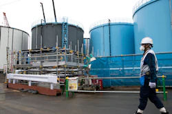 In this Feb. 23, 2017, file photo, an employee walks past storage tanks for contaminated water at the tsunami-crippled Fukushima Dai-ichi nuclear power plant of the Tokyo Electric Power Co. (TEPCO) in Okuma town, Fukushima prefecture, Japan. More than six years after a tsunami overwhelmed the Fukushima nuclear power plant, Japan has yet to reach consensus on what to do with a million tons of radioactive water, stored on site in around 900 large and densely packed tanks that could spill should another major earthquake or tsunami strike.