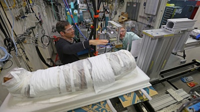 In this Nov. 27, 2017 photo, Argonne X-ray scientist Jonathan Almer, left, and Northwestern University Feinberg School of Medicine professor Stuart Stock, right, prepare to use high-energy X-ray beams to learn more about the 1,800-year-old mummified remains believed to be a 5-year-old girl in Lemont, Ill. Researchers from Northwestern and Argonne National Laboratory are using advanced technology to unwrap the mysteries of the mummy. They say high-energy beams from a synchrotron will provide molecular information about what is inside.