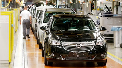 In this May 4, 2015 file photo Opel cars stand on the assembly line in the Opel car manufactory in Ruesselsheim, Germany. European automakers Opel and Vauxhall say there'll be no forced layoffs and all of their current plants will be maintained as they look to a new future under French owner PSA Group.