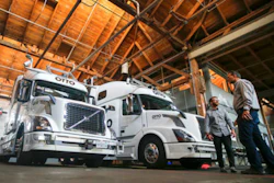 In this Thursday, Aug. 18, 2016, file photo, employees stand next to self-driving, big-rig trucks during a demonstration at the Otto headquarters, in San Francisco. Uber's self-driving startup Otto developed technology allowing big rigs to drive themselves. After taking millions of factory jobs, robots could be coming for a new class of worker: people who drive for a living.