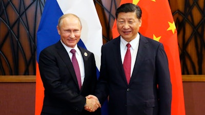 Russia's President Vladimir Putin, left, and Chinese President Xi Jinping shake hands during their meeting at the APEC Business Advisory Council dialogue in Danang, Vietnam Friday, Nov. 10, 2017.
