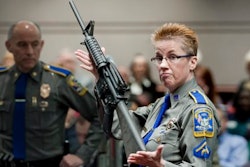 In this Jan. 28, 2013, file photo, firearms training unit Detective Barbara J. Mattson, of the Connecticut State Police, holds up a Bushmaster AR-15 rifle, the same make and model of gun used by Adam Lanza in the Sandy Hook School shooting, during a hearing of a legislative subcommittee, at the Legislative Office Building in Hartford, Conn.
