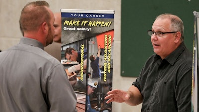 In this Thursday, Nov. 2, 2017, photo, a job recruiter looking for sheet metal workers, right, speaks with an attendee at a job fair in Cheswick, Pa. On Thursday, Nov. 16, 2017, the Labor Department reports on the number of people who applied for unemployment benefits a week earlier.