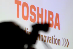 In this April 11, 2017, file photo, a photographer is silhouetted before a press conference at the Toshiba Corp. headquarters in Tokyo. Troubled Toshiba Corp. is selling 95 percent of its TV and other visual products subsidiary to Chinese electronics maker Hisense Group. Toshiba, which needs to sell parts of its business to survive, announced the 12.9 billion yen ($113 million) deal Tuesday, Nov. 14, 2017. It’s set to be completed by or after February 2018, pending regulatory approval and other steps.