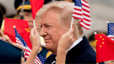 Children wave U.S. and Chinese flags as President Donald Trump arrives at Beijing Airport, Wednesday, Nov. 8, 2017, in Beijing, China. Trump is on a five country trip through Asia traveling to Japan, South Korea, China, Vietnam and the Philippines.