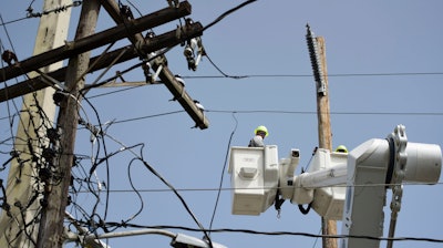 In this Oct. 19, 2017 file photo, a brigade from the Electric Power Authority repairs distribution lines damaged by Hurricane Maria in the Cantera community of San Juan, Puerto Rico. Puerto Rico's government scored a big win in court Monday, Nov. 13, 2017 after a judge rejected the appointment of a former military officer to oversee the U.S. territory's troubled power company.