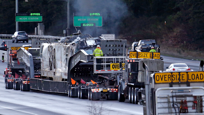 The engine from an Amtrak train that crashed onto Interstate 5 on Monday, is transported away from the scene, Wednesday, Dec. 20, 2017, in DuPont, Wash. Federal investigators in the deadly train wreck want to know whether the engineer was distracted by a second person in his cab as his train hurtled into a curve at more than twice the speed limit. The train took a 30 mph curve at 80 mph and plunged off an overpass, sending rail cars plummeting onto a busy highway south of Seattle.