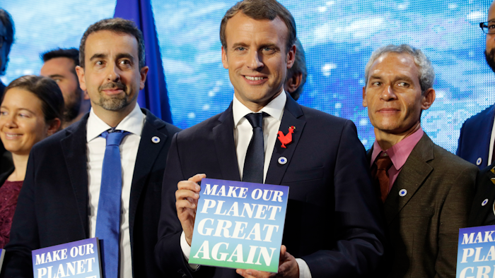 French President Emmanuel Macron, center, attends the 'Tech for Planet' event at the 'Station F' start up campus ahead of the One Planet Summit in Paris, France, Monday Dec. 11, 2017. It is a dream come true for U.S.-based climate scientists — the offer of all-expenses-paid life in France to advance their research in Europe instead of in the United States under climate skeptic President Donald Trump, two of the winners say.