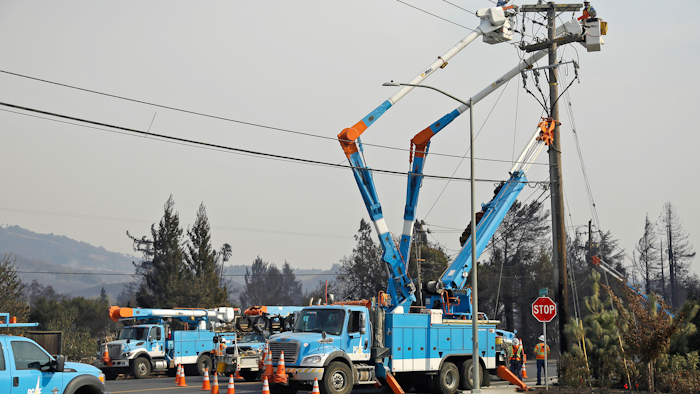 In this Oct. 11, 2017 file photo, a Pacific Gas & Electric crew works at restoring power along the Old Redwood Highway in Santa Rosa, Calif. California utility Pacific Gas & Electric Co. is suspending dividend payments to shareholders out of concern for any financial liability in Northern California wildfires. The utility's board announced the move in a statement Wednesday, Dec. 20, 2017.