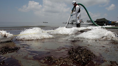 In this June 9, 2010 file photo, a worker uses a suction hose to remove oil washed ashore from the Deepwater Horizon spill, in Belle Terre, La. The Trump administration has halted an independent scientific study of offshore oil inspections by the federal safety agency created after the 2010 spill in the Gulf of Mexico. The National Academies of Sciences, Engineering and Medicine was told to cease review of the inspection program conducted by the federal Bureau of Safety and Environmental Enforcement. Established following the massive BP spill, the bureau was assigned the role of improving offshore safety inspections and federal oversight.