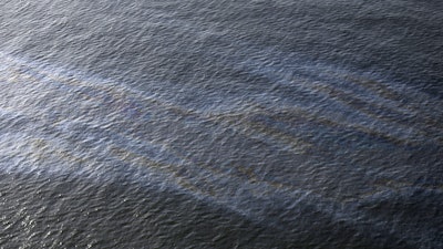 This March 31, 2015 file photo shows an oil sheen drifting from the site of the former Taylor Energy oil rig in the Gulf of Mexico, off the coast of Louisiana. Federal officials say they have found fresh evidence of an “ongoing oil release” at the site of a 13-year-old oil leak in the Gulf of Mexico.