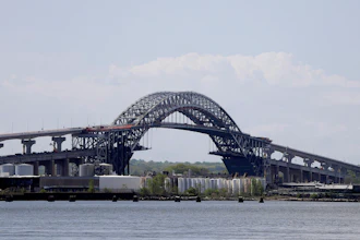 This May 2, 2017, file photo shows the Bayonne Bridge prior to a news conference announcing the bridge project completion, seen from Elizabeth, N.J. The elevation of the Bayonne Bridge was projected to cost about $1.3 billion before construction began more than four years ago. This week, the Port Authority of New York and New Jersey, which owns and operates the bridge, approved allocating between $350 million and $400 million more, an overrun of more than 25 percent.