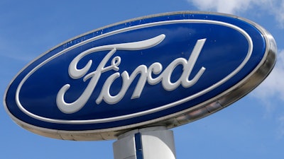 This Jan. 17, 2017, file photo shows a Ford sign at an auto dealership, in Hialeah, Fla. At least 30 percent of the new vehicles Ford will roll out in China by 2025 will be electric, with Beijing pushing hard to improve air quality for people living in smoke-choked cities. Ford said Tuesday, Dec. 5, that the new electric cars will fall under the Lincoln brand and its namesake.