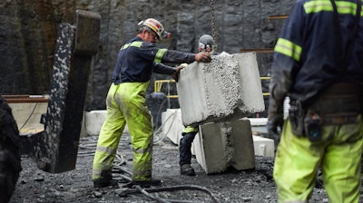 In this Wednesday, June 7, 2017, file photo, a worker lowers a concrete block at the site of a new coal mine in Friedens, Pa. On Friday, Dec. 15, 2017, the Federal Reserve said mining activity climbed 2 percent in November, while manufacturing activity rose 0.2 percent.