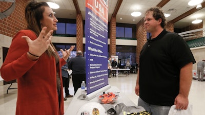 In this Thursday, Nov. 2, 2017, photo, a recruiter from a driller in the shale gas industry, left, speaks with an attendee at a job fair in Cheswick, Pa. On Friday, Dec. 8, 2017, the U.S. government issues the November jobs report.