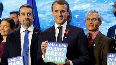 French President Emmanuel Macron, center, attends the 'Tech for Planet' event at the 'Station F' start up campus ahead of the One Planet Summit in Paris, France, Monday Dec. 11, 2017. It is a dream come true for U.S.-based climate scientists — the offer of all-expenses-paid life in France to advance their research in Europe instead of in the United States under climate skeptic President Donald Trump, two of the winners say.