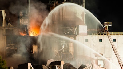 In this photo provided by Jeff Lange, firefighters work at the scene following an explosion and fire at the Didion Milling plant in Cambria, Wis., Thursday, June 1, 2017. Recovery crews searched a mountain of debris on Thursday following a fatal explosion late Wednesday at the corn mill plant, which injured about a dozen people and leveled parts of the sprawling facility in southern Wisconsin, authorities said.