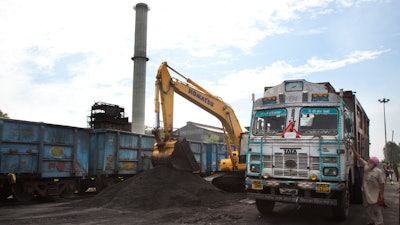 In this July 14, 2017 file photo, domestically produced petroleum coke is loaded onto a truck to be transported to factories, at a railway station in Rampur, about 210 kilometers (130 miles) from New Delhi, India.India's government says it plans to phase out imports of a dirty fuel known as petroleum coke, or 'petcoke,' after an Associated Press investigation found U.S. oil refineries are exporting vast quantities of the product to India. But when it comes to domestic use, the Indian government seems to be going in a different direction. The government this week argued in court that restrictions on petcoke around polluted New Delhi should be eased for certain low-impact industries. The move has infuriated environmentalists.