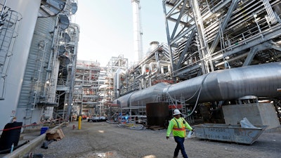 In this Nov. 16, 2015 file photo, a worker walks through a section of the Mississippi Power Co. carbon capture plant in DeKalb, Miss. Regulators have reached a settlement with Mississippi Power Co. on how much customers should pay for a troubled $7.5 billion power plant once touted as the future of coal. The unit of Atlanta-based Southern Co. is agreeing to lower the price tag on its Kemper County power plant by $85 million, its second round of concessions in two weeks. Shareholders have already lost $6 billion.
