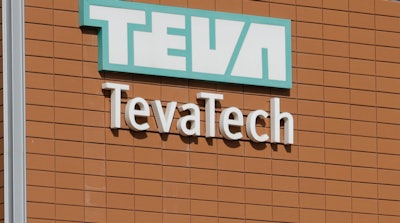 A man walks out of Teva Pharmaceutical facility building in Neot Hovav, Israel, Thursday, Dec. 14, 2017. Teva Pharmaceutical Industries Ltd., the world's largest generic drugmaker, says it is laying off 14,000 workers as part of a global restructuring. The company said Thursday that the layoffs represent over 25 percent of its global work force.