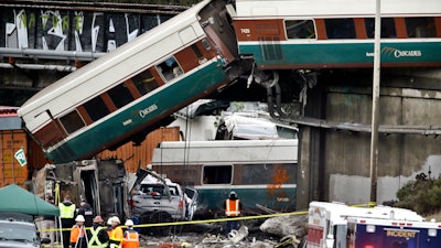 Cars from an Amtrak train lay spilled onto Interstate 5 below alongside smashed vehicles as some train cars remain on the tracks above Monday, Dec. 18, 2017, in DuPont, Wash. The Amtrak train making the first-ever run along a faster new route hurtled off the overpass Monday near Tacoma and spilled some of its cars onto the highway below, killing some people, authorities said. Seventy-eight passengers and five crew members were aboard when the train moving at more than 80 mph derailed about 40 miles south of Seattle before 8 a.m., Amtrak said.