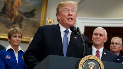 President Donald Trump speaks before signing a policy directive to send American astronauts back to the moon, and eventually Mars, in the Roosevelt Room of the White House, Monday, Dec. 11, 2017, in Washington. From left, NASA astronaut Peggy Whitson, Trump, Vice President Mike Pence, and Vice Chairman of the Joint Chiefs of Staff Gen. Paul J. Selva.