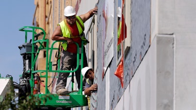 In this Friday, Oct. 6, 2017, photo, workers build an apartment and retail complex in Nashville, Tenn. On Wednesday, Dec. 6, 2017, the Labor Department issues revised data on productivity in the third quarter.