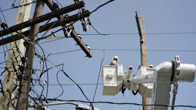 In this Oct. 19, 2017 file photo, a brigade from the Electric Power Authority repairs distribution lines damaged by Hurricane Maria in the Cantera community of San Juan, Puerto Rico. Puerto Rico's government scored a big win in court Monday, Nov. 13, 2017 after a judge rejected the appointment of a former military officer to oversee the U.S. territory's troubled power company.