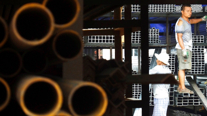In this Monday, Aug. 1, 2016 file photo, laborers work at a steel market in Yichang in central China's Hubei province. The head of an American business group said Tuesday, Jan. 30, 2018 that Chinese officials have warned 'there will be retaliation' if President Donald Trump launches trade remedies in disputes over technology, steel and other issues.