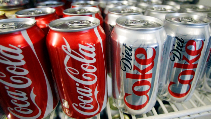 In this March 17, 2011, file photo, cans of Coca-Cola and Diet Coke sit in a cooler in Anne's Deli in Portland, Ore. The Coca-Cola Co. plans to help collect and recycle a bottle or can for every one that it sells by 2030. The beverage company is also working on making all of its packaging 100 percent recyclable worldwide. Coca-Cola said Friday, Jan. 19, 2018, that it's creating bottles with more recycled content by developing plant-based resins.