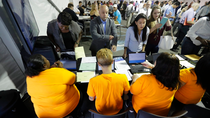 In this Wednesday, Aug. 2, 2017, file photo, job candidates are processed during a job fair at the Amazon fulfillment center in Robbinsville Township, N.J. On Friday, Jan. 5, 2018, the U.S. government issues the December jobs report.